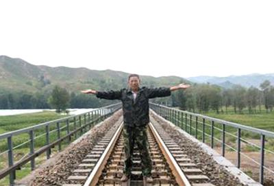 卢伟接受媒体采访时，还原了当时在铁轨中间迎面拦火车的动作。
