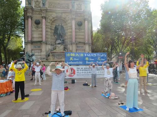 法國巴黎法輪功學員八月二十日再次來到聖米歇爾廣場，向市民及遊客展示法輪功法、講真相、征集簽名。