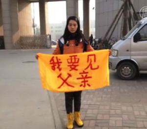 女兒卞曉暉在石家莊監獄門口舉起橫幅“我要見父親”。